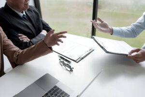 The businessman boss or hr is investigating the misconduct of the employee for corrective action.